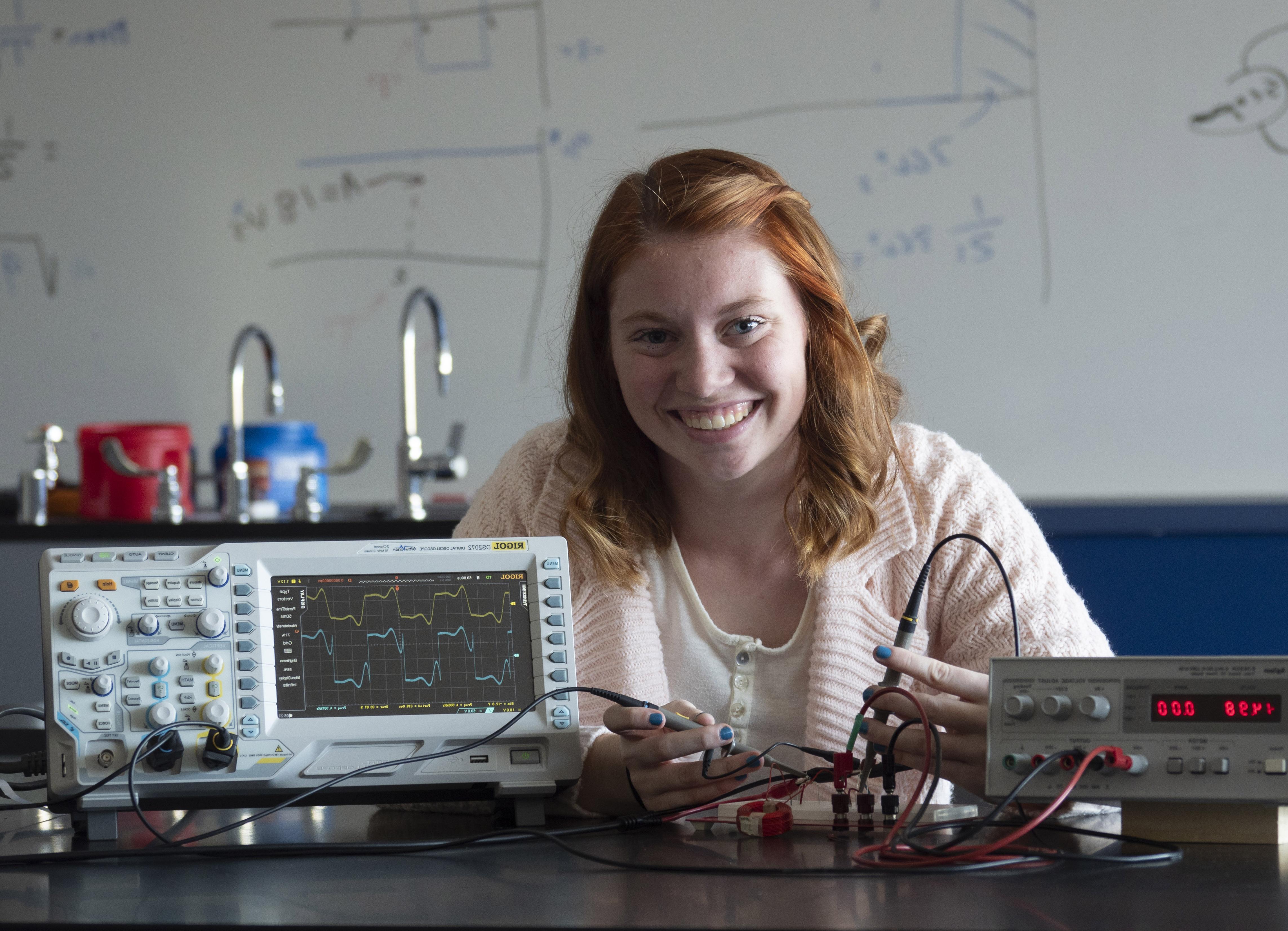 An engineering student hooking wires up to a board