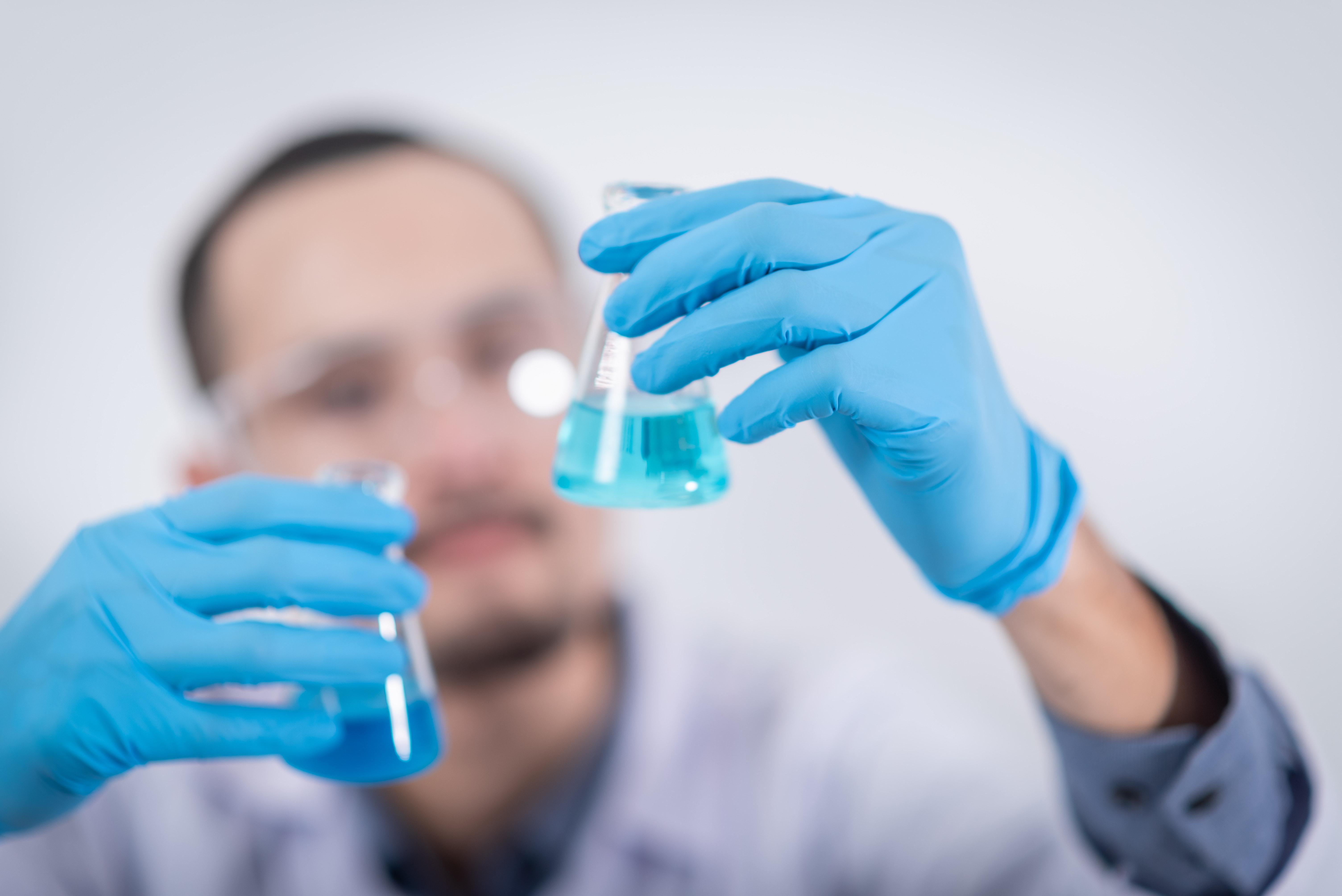 Lab technician examining petri dish.