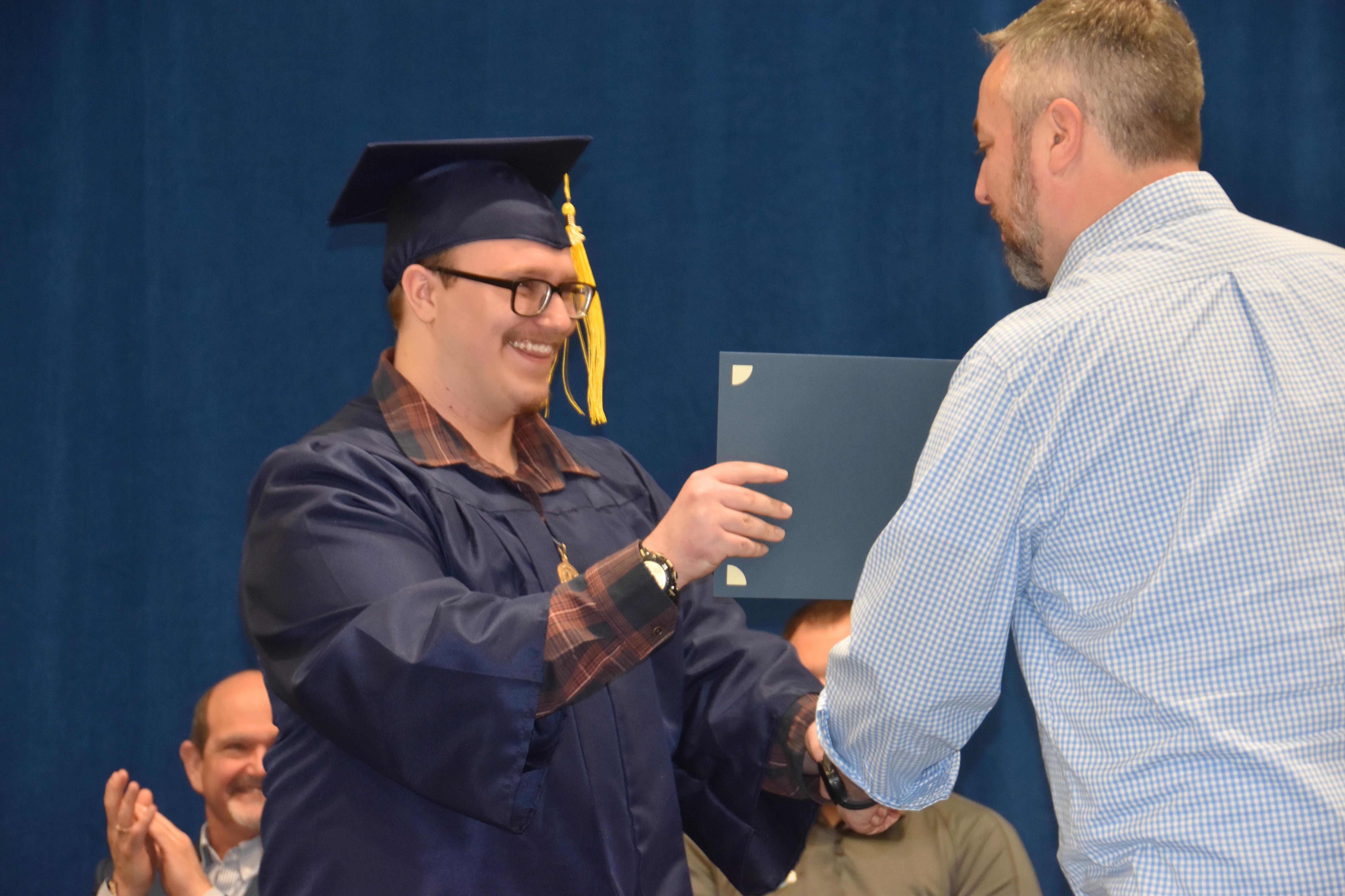 Goetschel presents a diploma to a Cohort 50 apprentice.